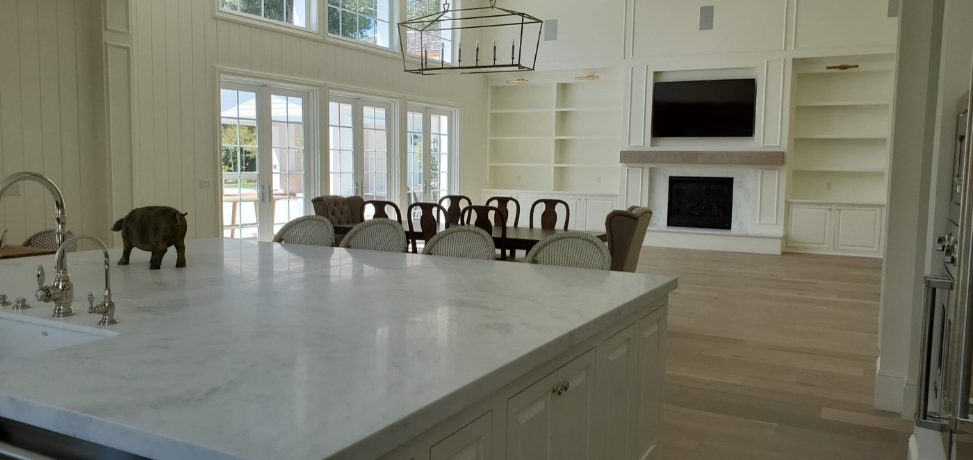 Large TV mounted above a marble fireplace in an upscale Southern Highlands great room